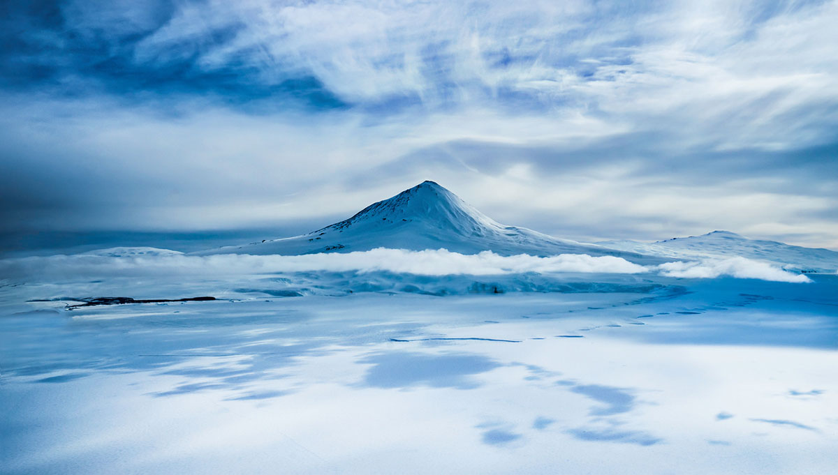 Un volcan semblant flotter au-dessus des nuages