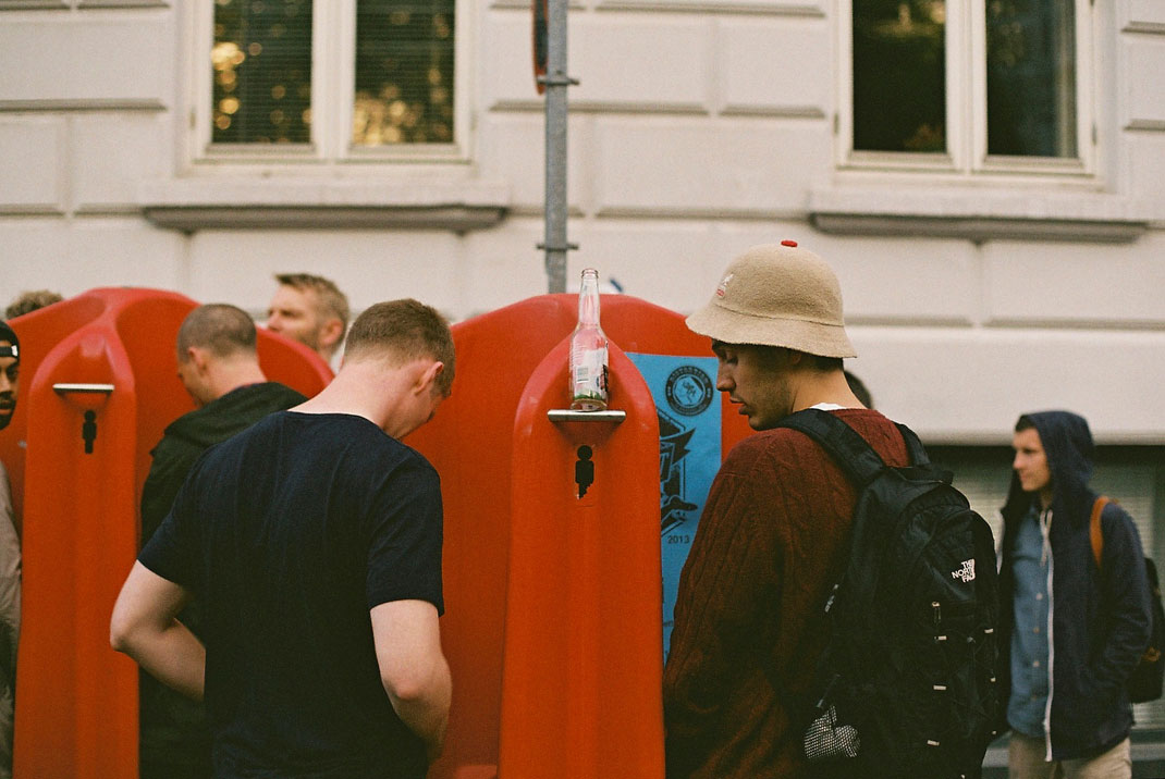 Deux personnes aux urinoirs publics